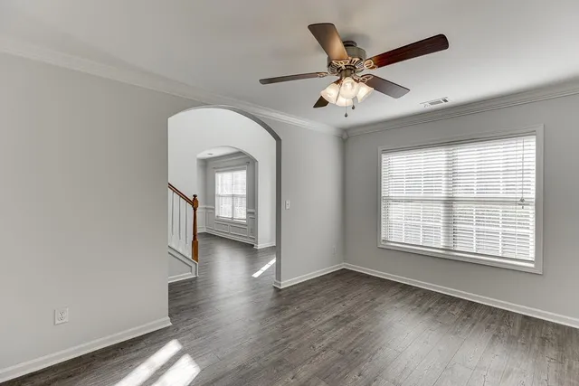 a view of a livingroom with a ceiling fan and wooden floor