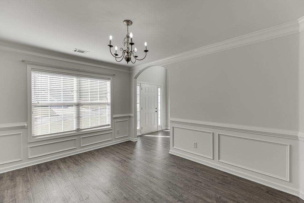926 Red Wolf Court Dacula, GA 30019 - Photo 6 of 47 a view of an empty room with a window and wooden floor