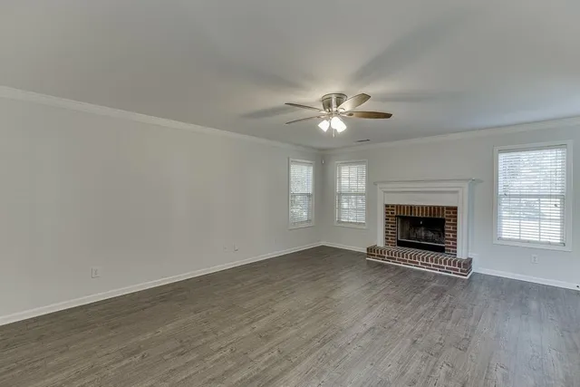 wooden floor fireplace and windows in an empty room