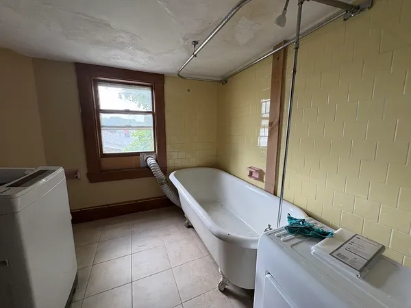 a bathroom with a tub sink and window