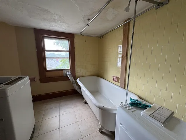 a bathroom with a tub sink and window