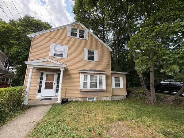 a view of a yard in front of a house with large trees