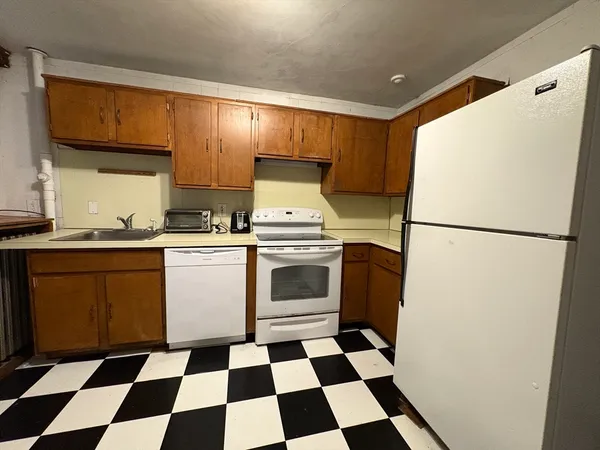a kitchen with a refrigerator a stove and a sink