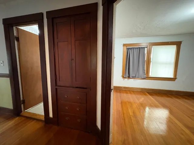 an empty room with wooden floor and a window