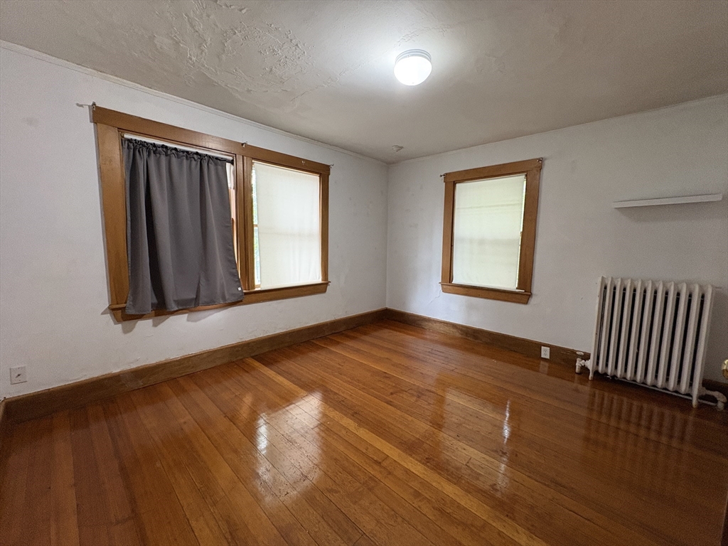 28 Woodward Street, Unit 2 Newton, MA 02461 - Photo 8 of 20 a view of an empty room with wooden floor and a window
