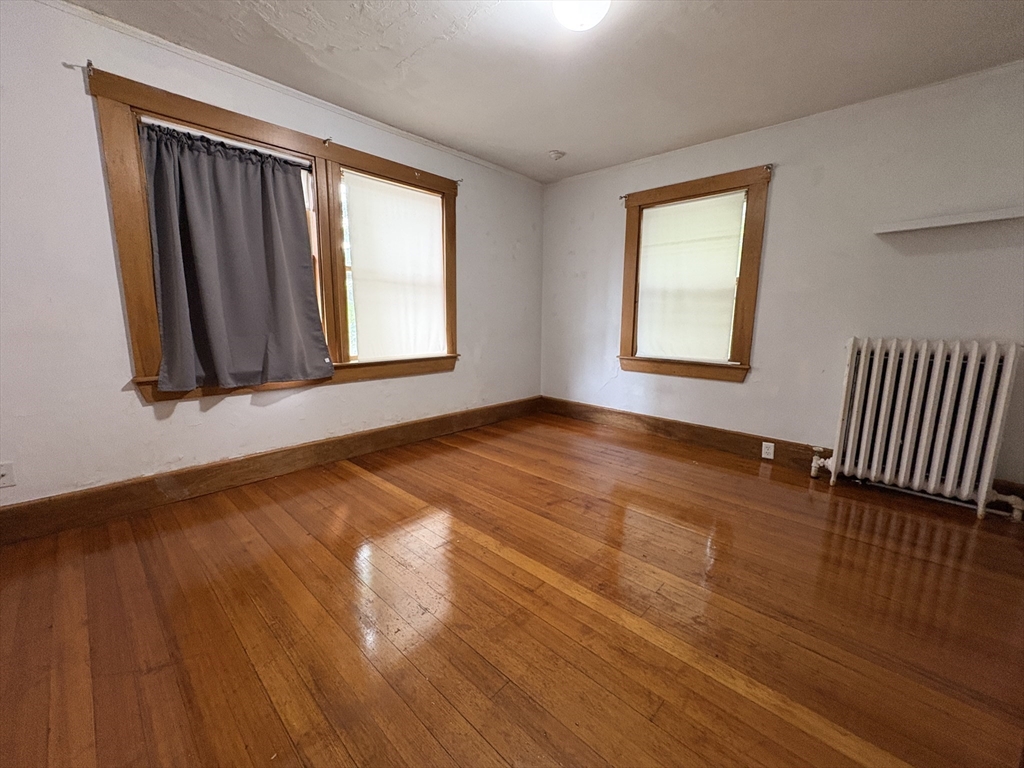 28 Woodward Street, Unit 2 Newton, MA 02461 - Photo 9 of 20 a view of an empty room with wooden floor and a window
