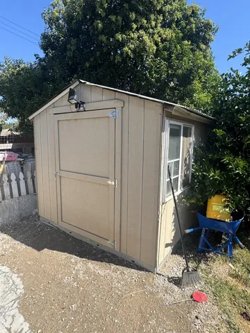 a backyard of a house with wooden fence and a potted plant