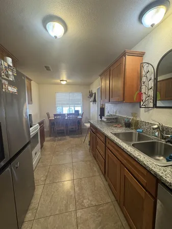 a kitchen with stainless steel appliances granite countertop a sink stove and refrigerator