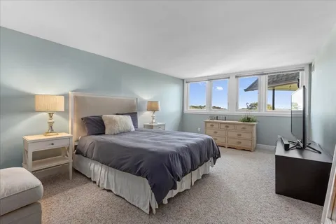 a spacious bedroom with a bed and a dresser