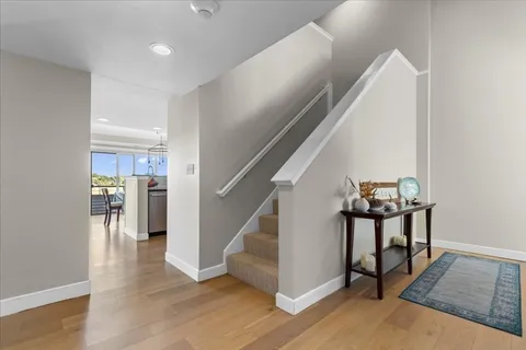 a view of a hallway with wooden floor and staircase