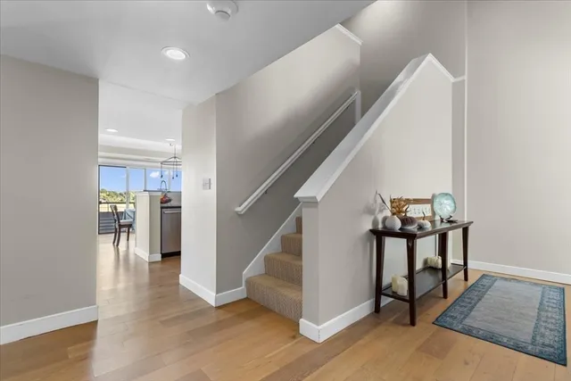 a view of a hallway with wooden floor and staircase