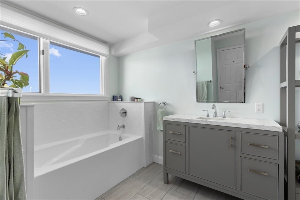 29 Ladds Way, Unit 29 Scituate, MA 02066 - Photo 26 of 33 a bathroom with a bathtub sink and mirror