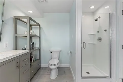 a bathroom with a granite countertop sink toilet and shower
