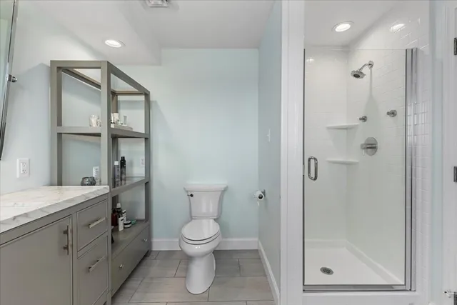 a bathroom with a granite countertop sink toilet and shower