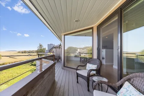 a view of a balcony dining table and chairs with wooden floor