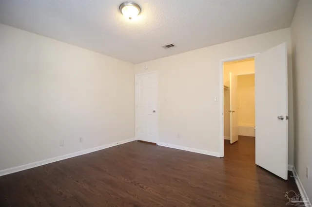 an empty room with wooden floor and closet