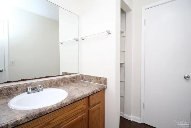 a bathroom with a granite countertop sink and a mirror