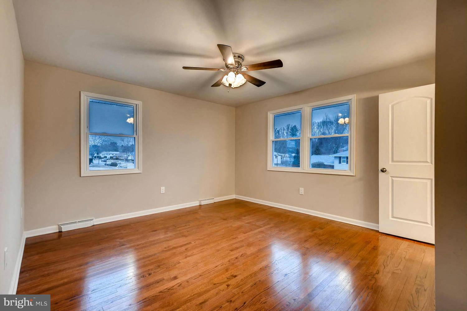 4515 Tapscott Road Pikesville, MD 21208 - Photo 12 of 28 a view of an empty room with window and wooden floor