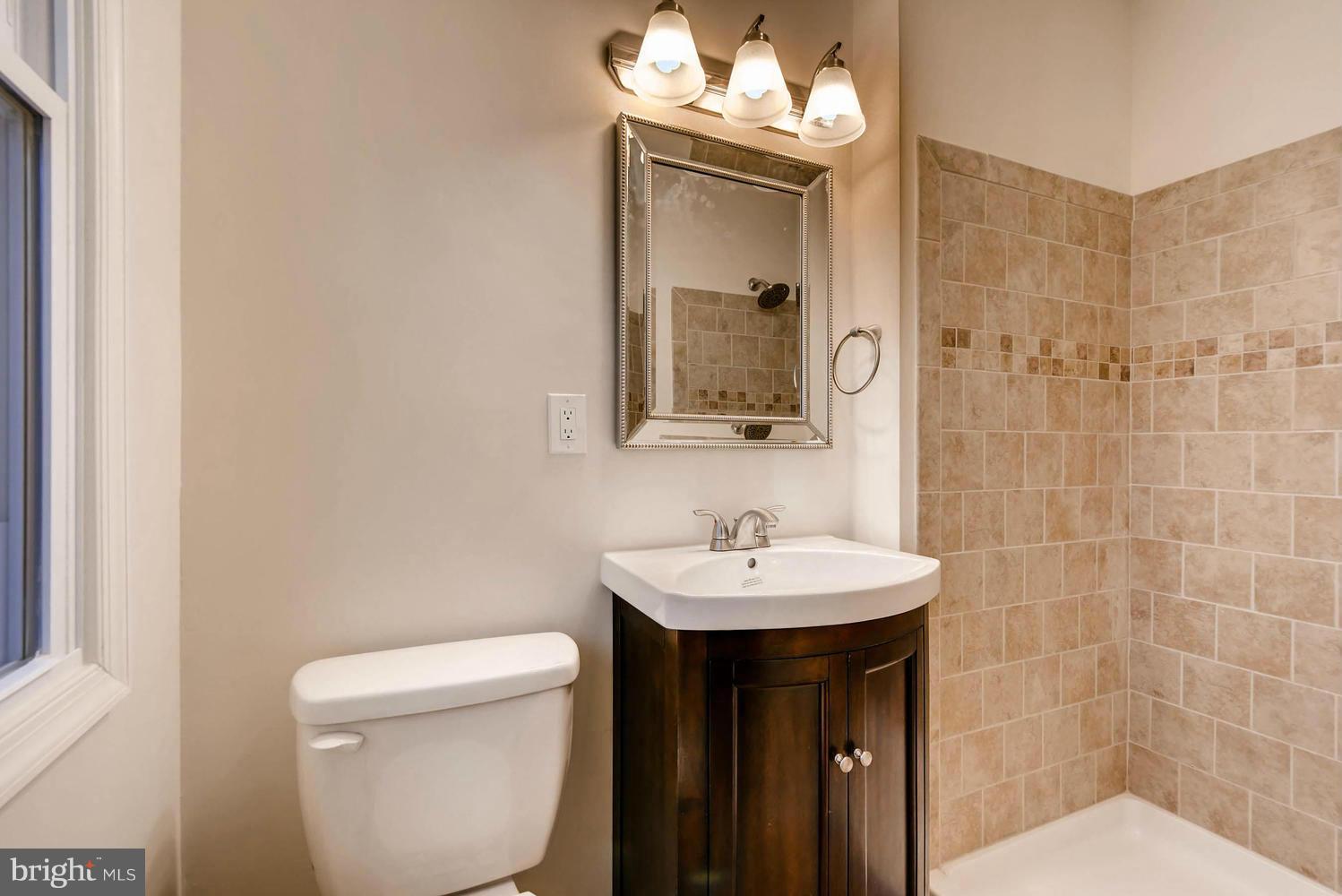 4515 Tapscott Road Pikesville, MD 21208 - Photo 14 of 28 a bathroom with a sink a toilet and shower