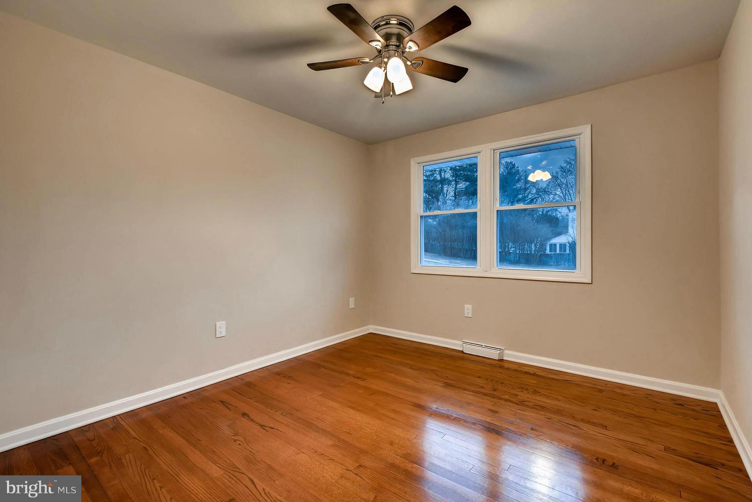 4515 Tapscott Road Pikesville, MD 21208 - Photo 15 of 28 a view of an empty room with window and wooden floor