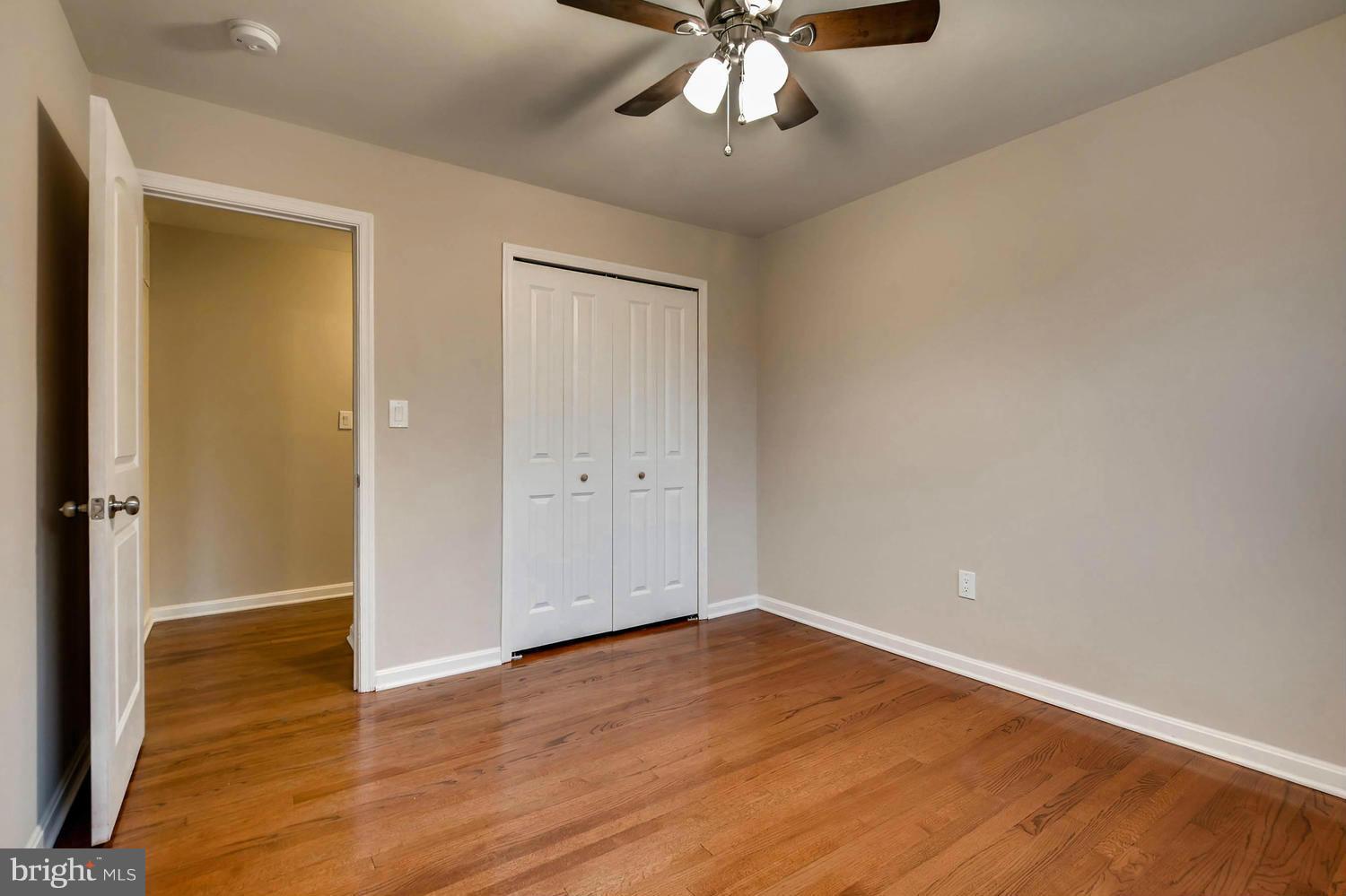 4515 Tapscott Road Pikesville, MD 21208 - Photo 16 of 28 an empty room with wooden floor closet and windows