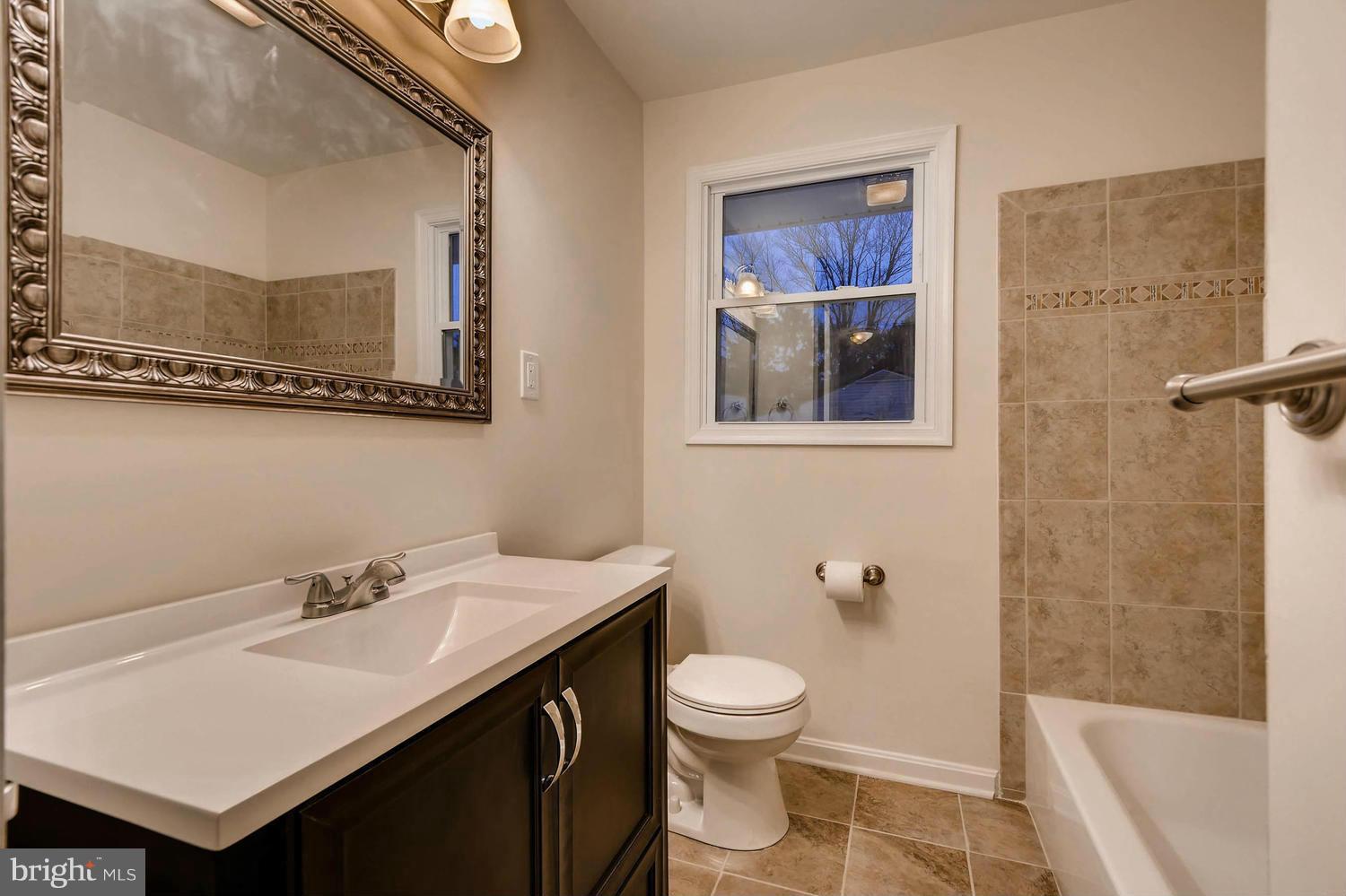 4515 Tapscott Road Pikesville, MD 21208 - Photo 17 of 28 a bathroom with a sink and a mirror