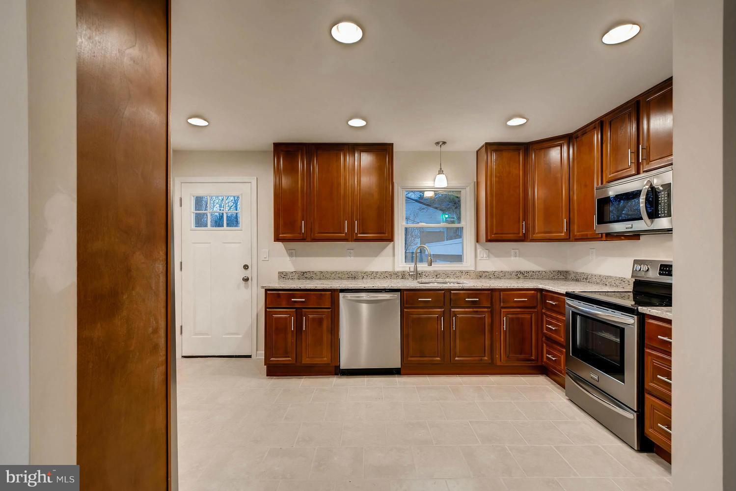 4515 Tapscott Road Pikesville, MD 21208 - Photo 5 of 28 a large kitchen with stainless steel appliances granite countertop a sink and a stove