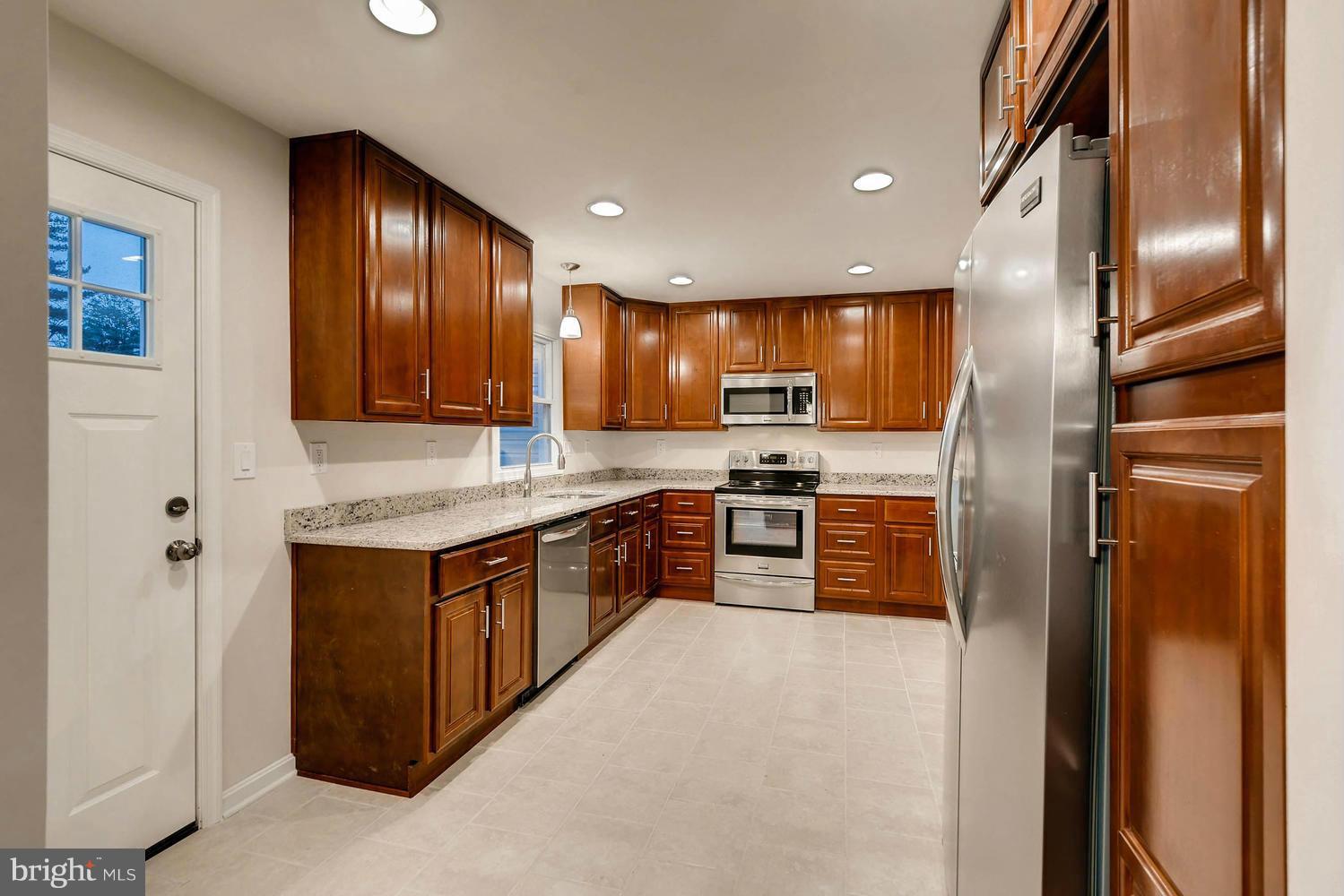 4515 Tapscott Road Pikesville, MD 21208 - Photo 7 of 28 a kitchen with stainless steel appliances granite countertop a refrigerator and a sink