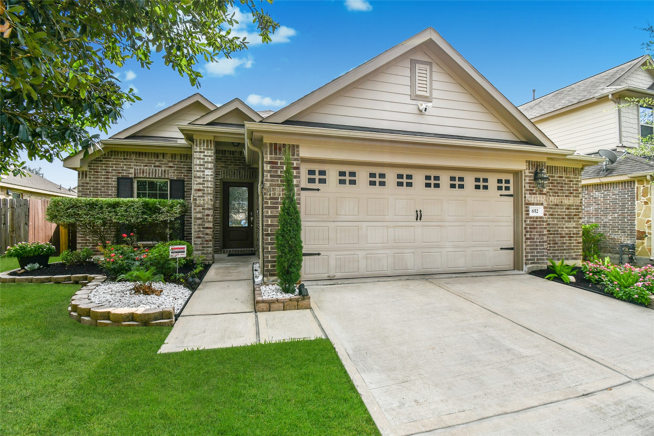 652 Maple Point Drive East Conroe, TX 77301 - Photo 1 of 35 This charming single-story home features a well-maintained brick exterior with a two-car garage. The front yard is beautifully landscaped with trimmed bushes, colorful flowers, and a neat lawn. A walkway leads to a welcoming covered entryway.