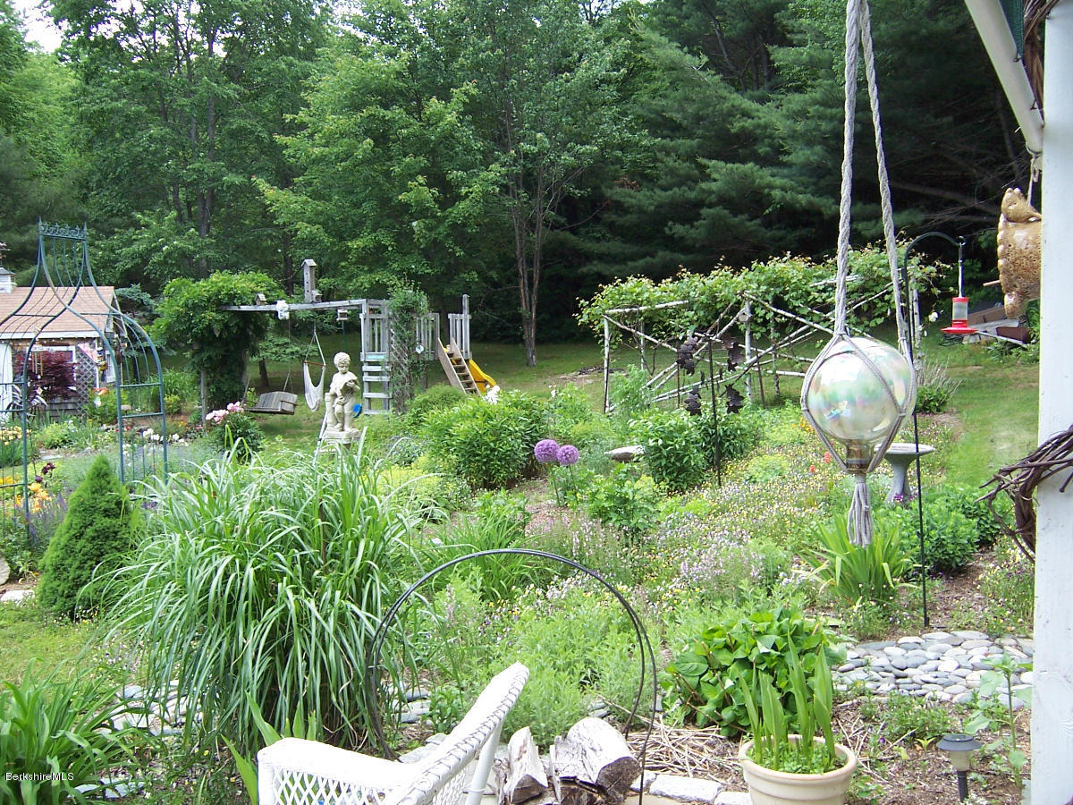 44 Stonehouse Road Washington, MA 01223 - Photo 21 of 56 a backyard of a house with table and chairs potted plants and large tree