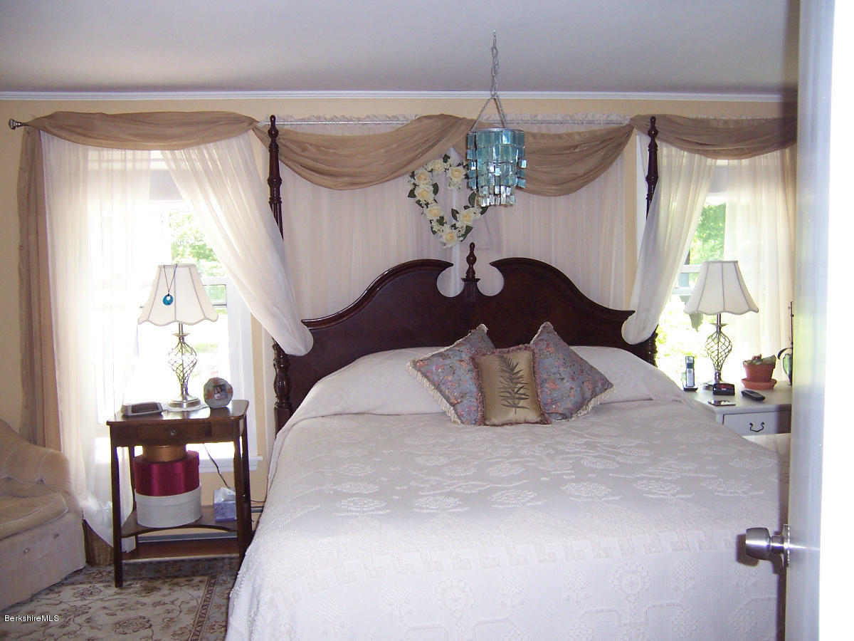 44 Stonehouse Road Washington, MA 01223 - Photo 43 of 56 a large bed sitting in a room next to a window and a chandelier