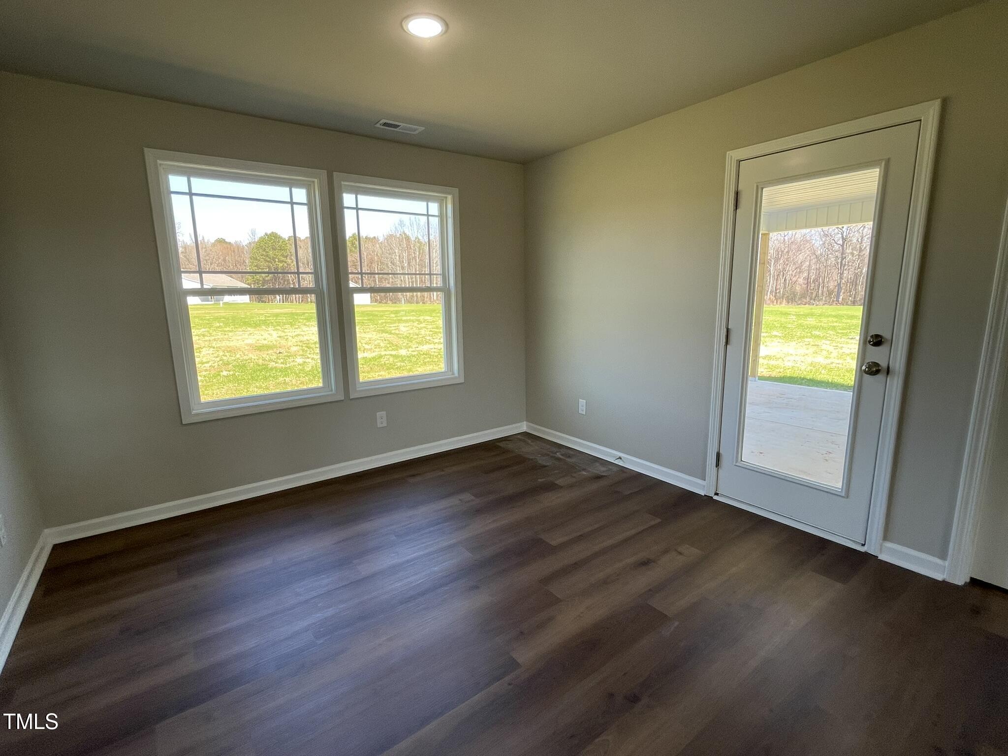 181 Pate Landing Drive Selma, NC 27576 - Photo 5 of 15 a view of an empty room with wooden floor and a window