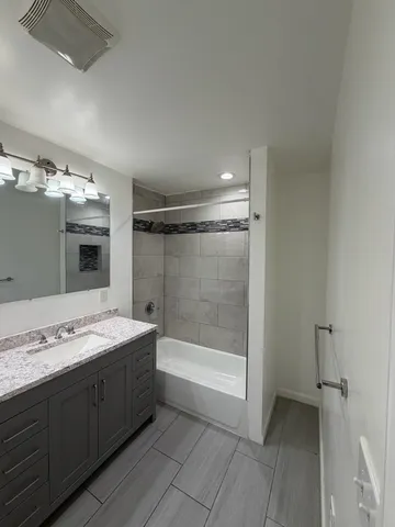 a bathroom with a tub sink and mirror