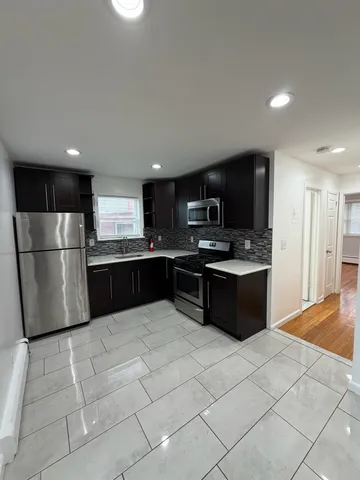 a large kitchen with a refrigerator and a stove top oven