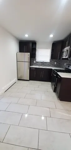 a large white kitchen with a cabinetry a sink and a stove top oven