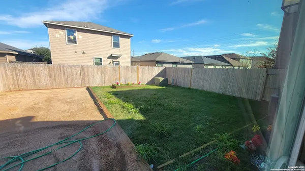 a view of a backyard with wooden fence
