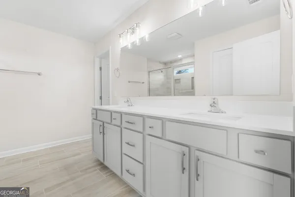 a bathroom with double sink and a mirror