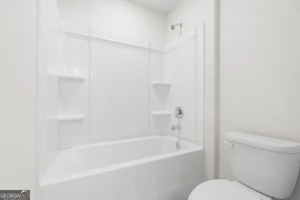 a white bath tub sitting next to a white toilet