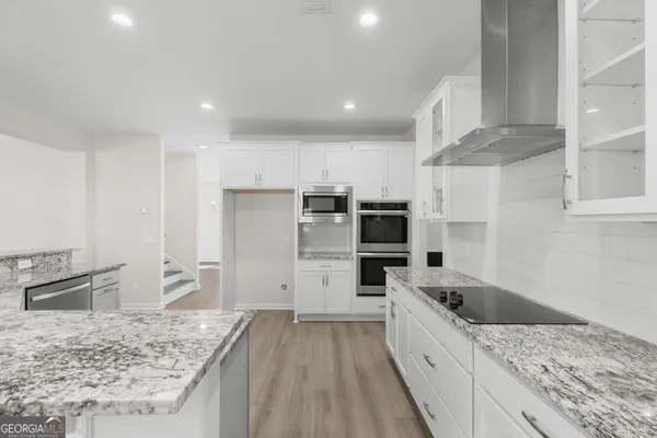 a large kitchen with a stove a sink and a refrigerator