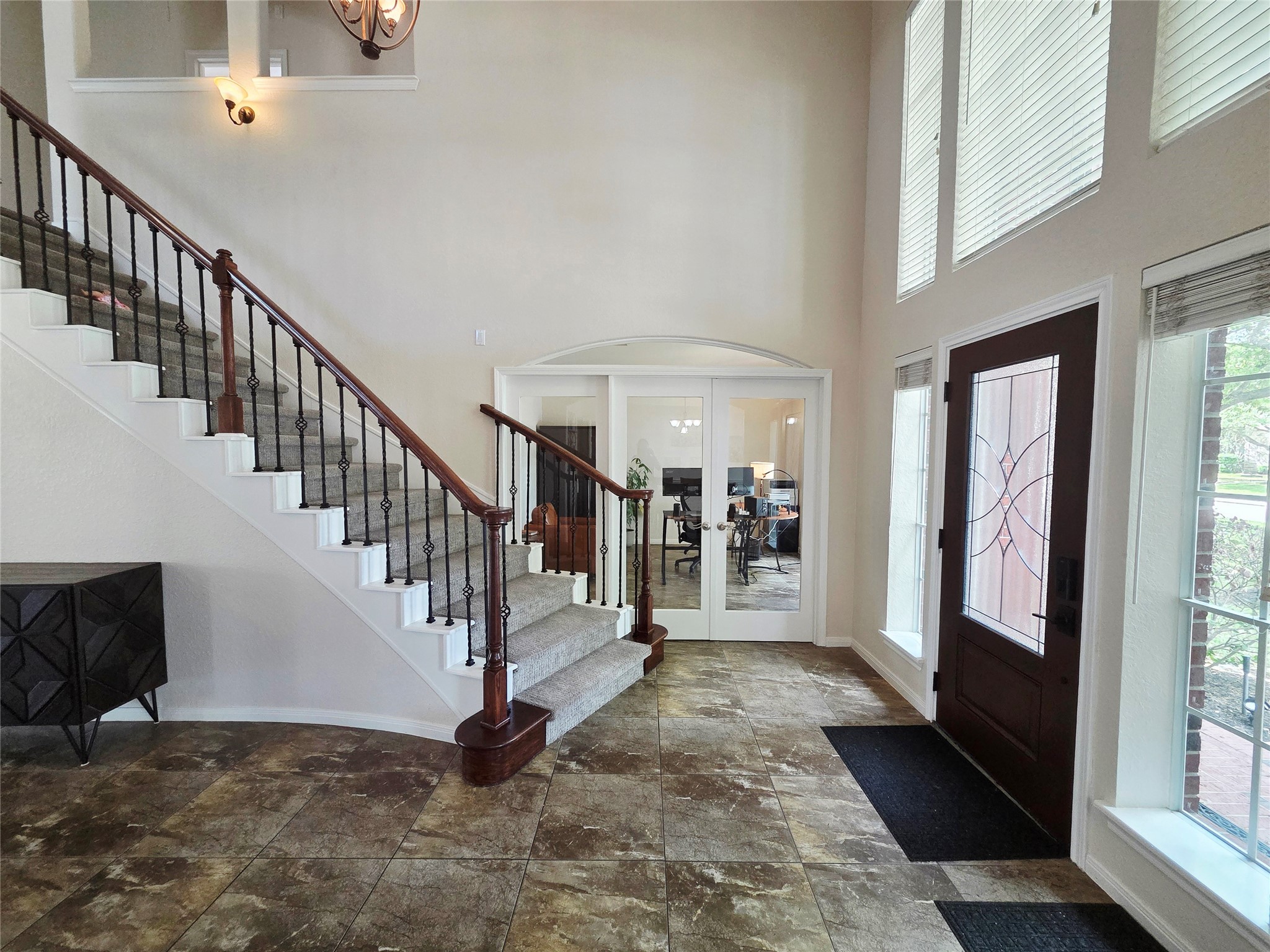 6010 Foxland Court Spring, TX 77379 - Photo 3 of 43 Enjoy a spacious and elegant entryway with high ceilings and large windows, allowing plenty of natural light. Notice the glass-paneled double doors leading to the office.