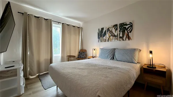 a bedroom with a bed and flat screen tv