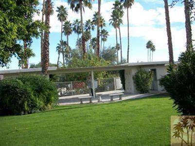 a view of a chair and table in the garden and trees