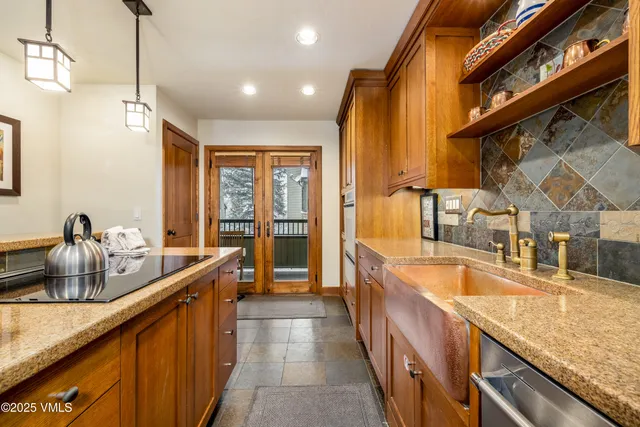 a large kitchen with kitchen island a large window a sink and stainless steel appliances