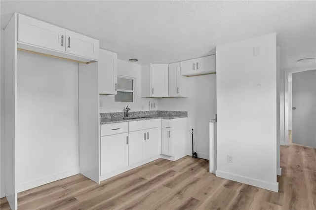 a kitchen with granite countertop white cabinets and white appliances