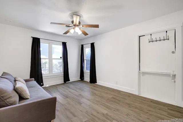 a living room with furniture and a ceiling fan