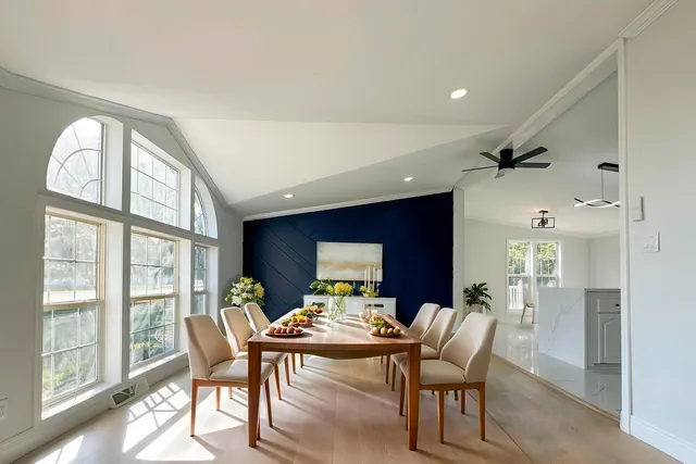 a living room with furniture a floor to ceiling window and a flat screen tv