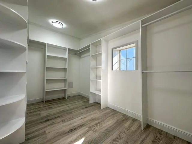 a room with walk in closet and wooden floor