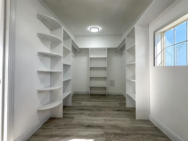 a view of walk in closet with empty racks
