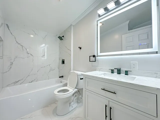 a bathroom with a toilet a bath tub a sink and mirror