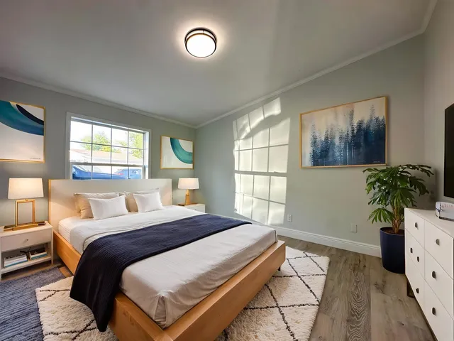 a bedroom with a bed and a potted plant